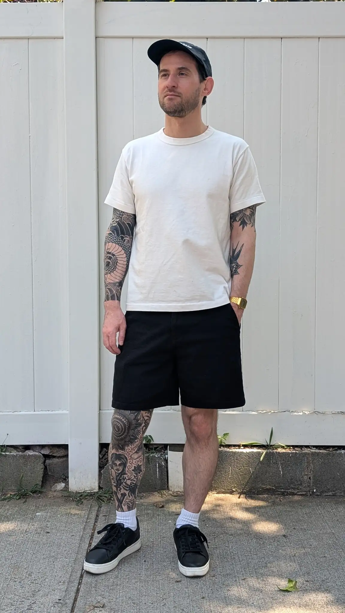 Black trouser shorts with a crisp white tee and minimalist sneakers