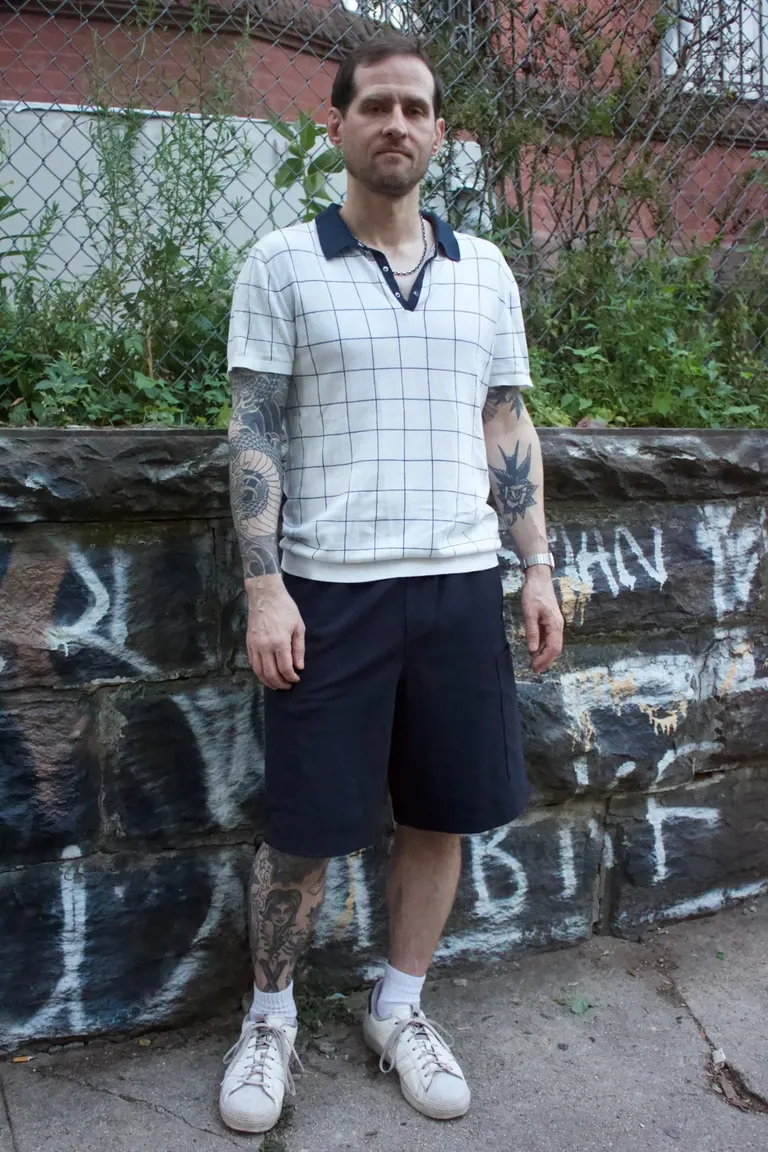 navy shorts outfit with knit polo closeup