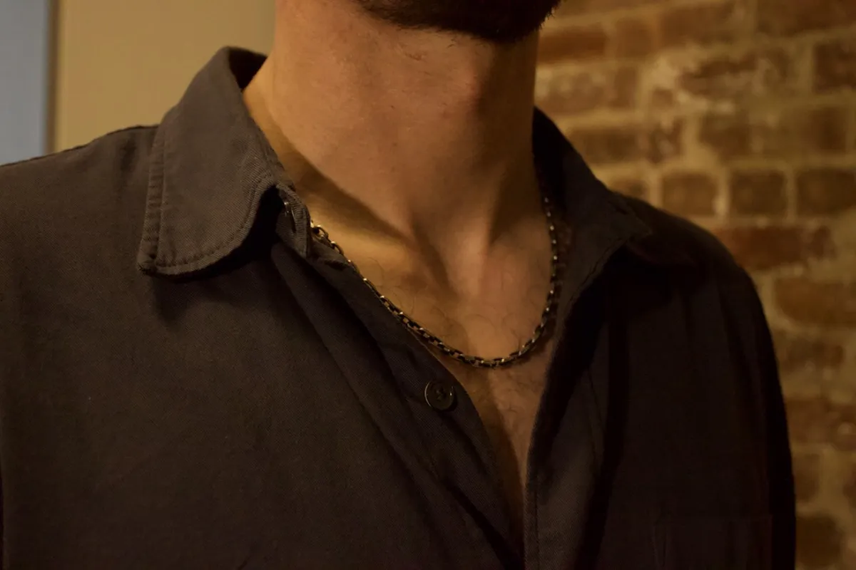 Oxidized silver chain worn with polo shirt